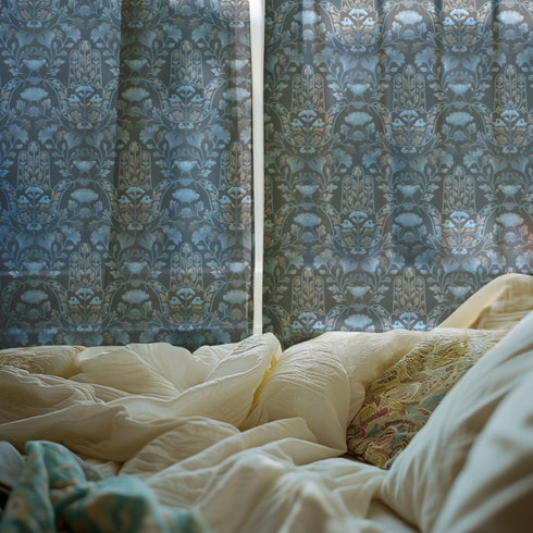 Sheer curtain panel featuring repeating gold hamsa hands surrounded by blue botanical flowers and leaves on dark navy background. Linen-textured polyester fabric filters light while providing elegant window covering with protective symbolism for bohemian or Victorian interiors.
